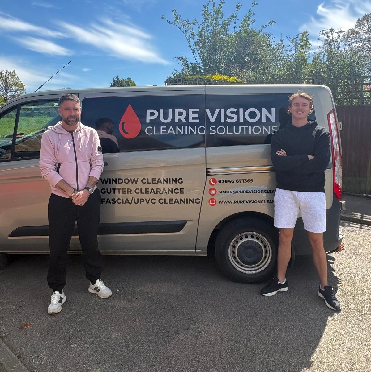 Two men standing in front of a Pure Vision Cleaning Solutions van with window cleaning and gutter clearance services advertised on its side